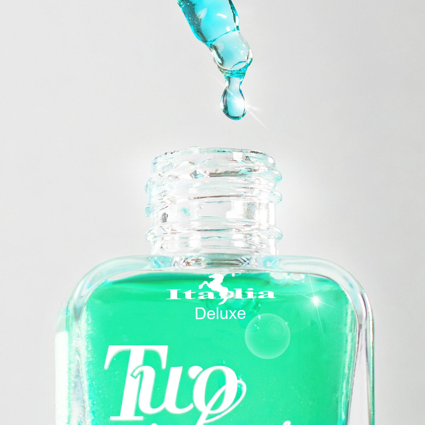 Turquoise face serum bottle with dropper labeled 'Italia Deluxe Two Phase' on a light gray background