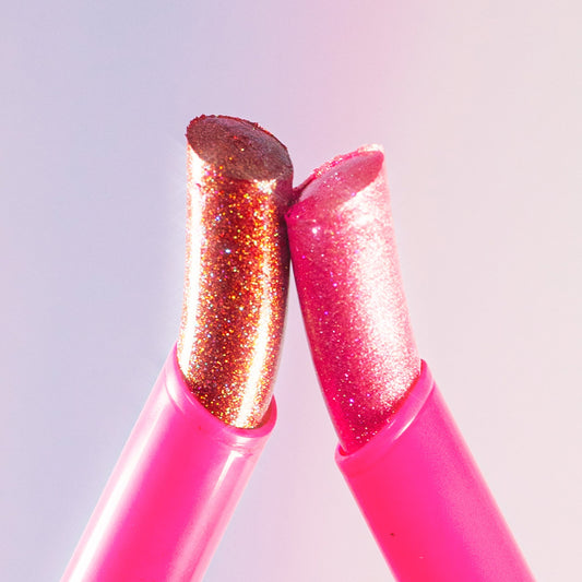 Two glitter jelly sticks on a light pink background