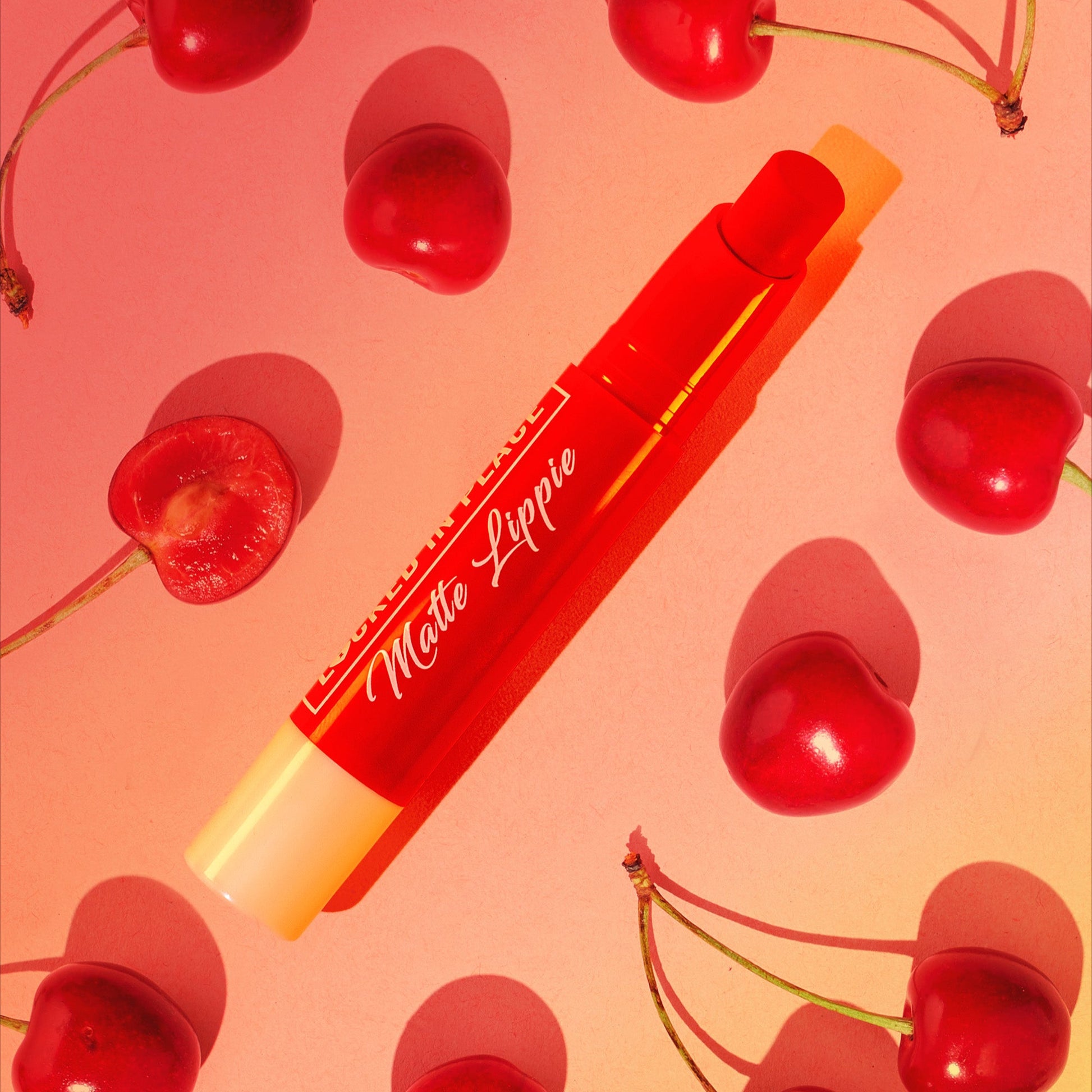italia deluxe nonstransfer, colorstay, matte lippies on a yellow, red, pink accents background with cherries, it is cherry flavored, cherry scent. 