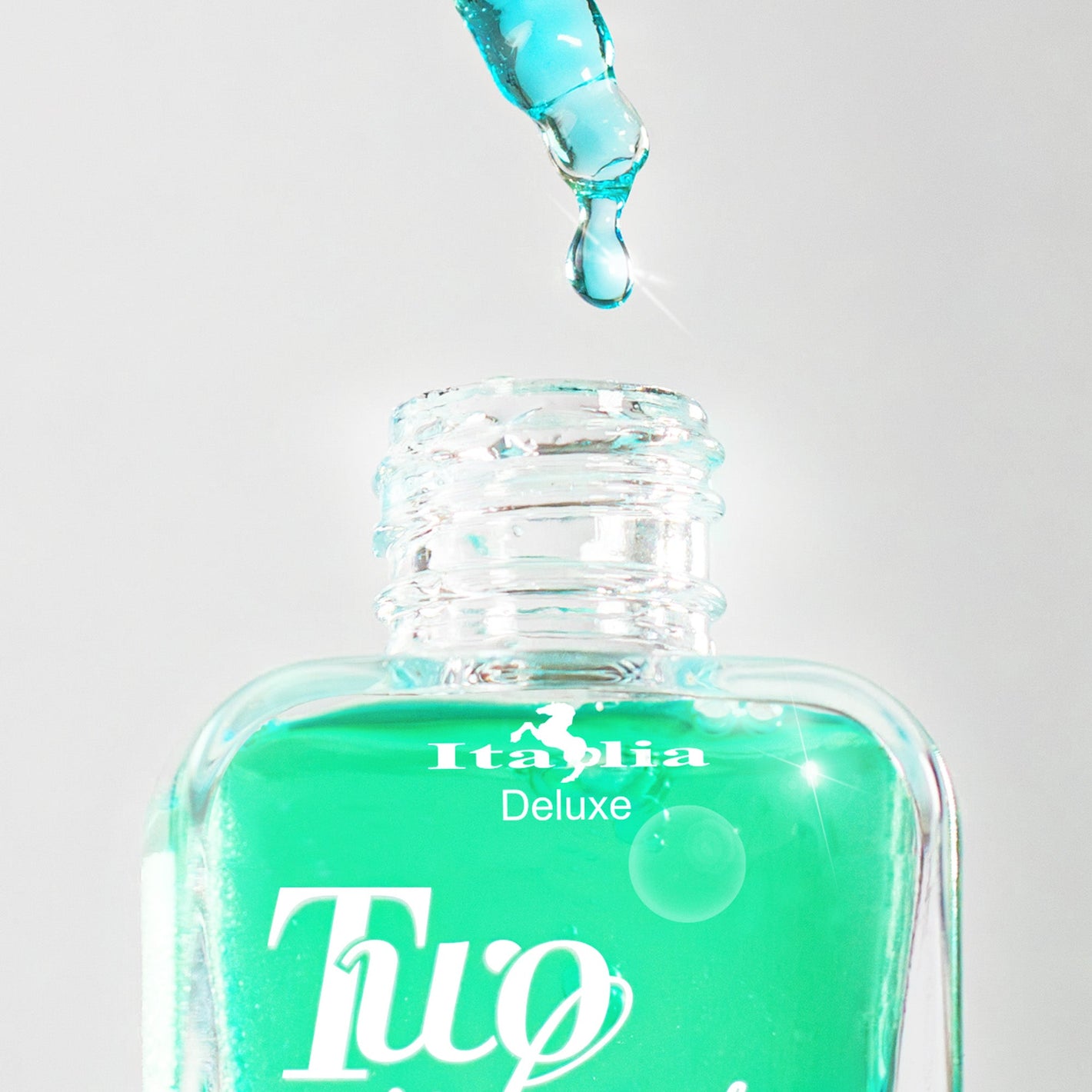 Turquoise face serum bottle with dropper labeled 'Italia Deluxe Two Phase' on a light gray background