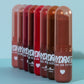 Six Hydra Hit  lip gloss balm tubes in a gradient of red, pink, and brown shades, lined up on a light blue surface against a matching light blue background.