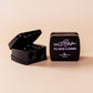 black cosmetic sharpener with 'Too Glam to Give a Damn' text on a beige background