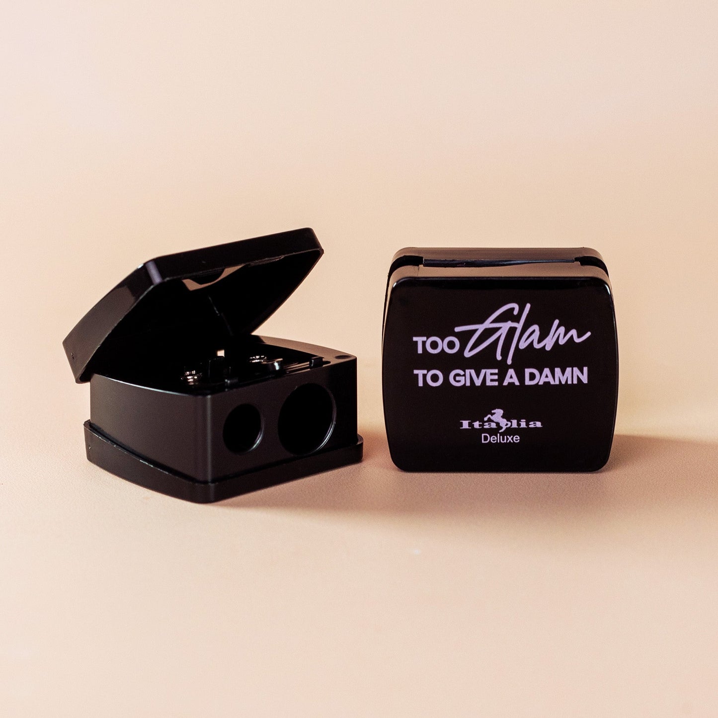 black cosmetic sharpener with 'Too Glam to Give a Damn' text on a beige background